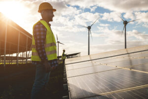 People working for solar panels and wind turbines – Renewable energy concept – Soft focus on man face
